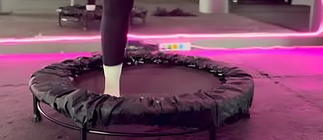 Pie apoyado sobre una mini cama elástica negra en el estudio
